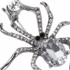 Three vintage crystal spider brooches, silver, gold and black alloy pins, Muslim-style white display stand undefined
